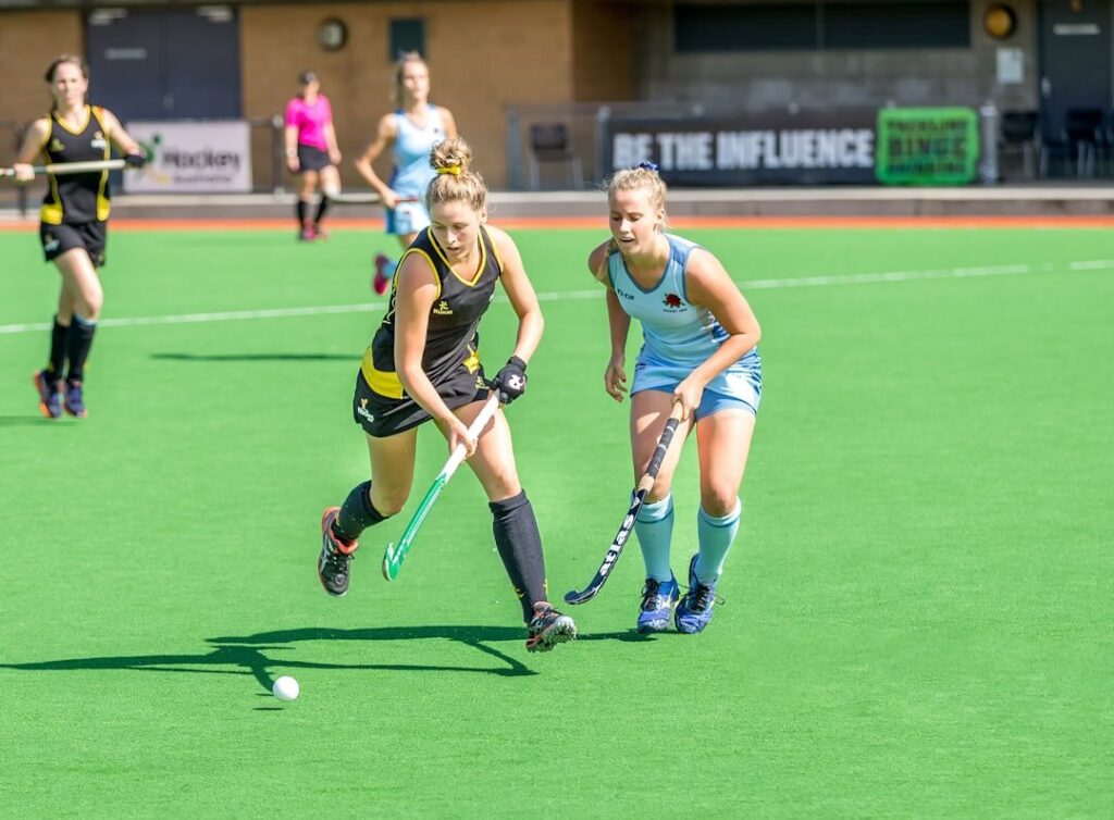 Een damesteam dat hockey speelt en sportactiviteiten vertegenwoordigt.